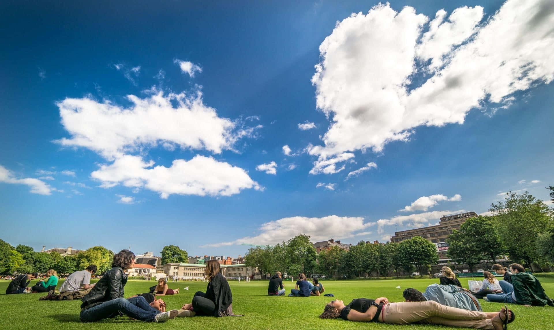 Students Relaxing On Campus Lawn Background