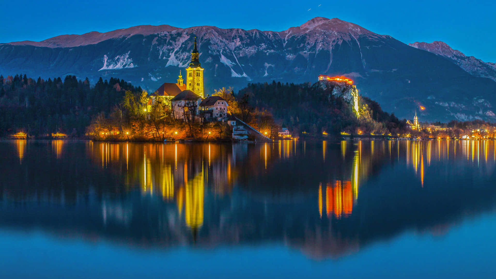 Stunning Lights Illuminating Lake Bled's Church Background