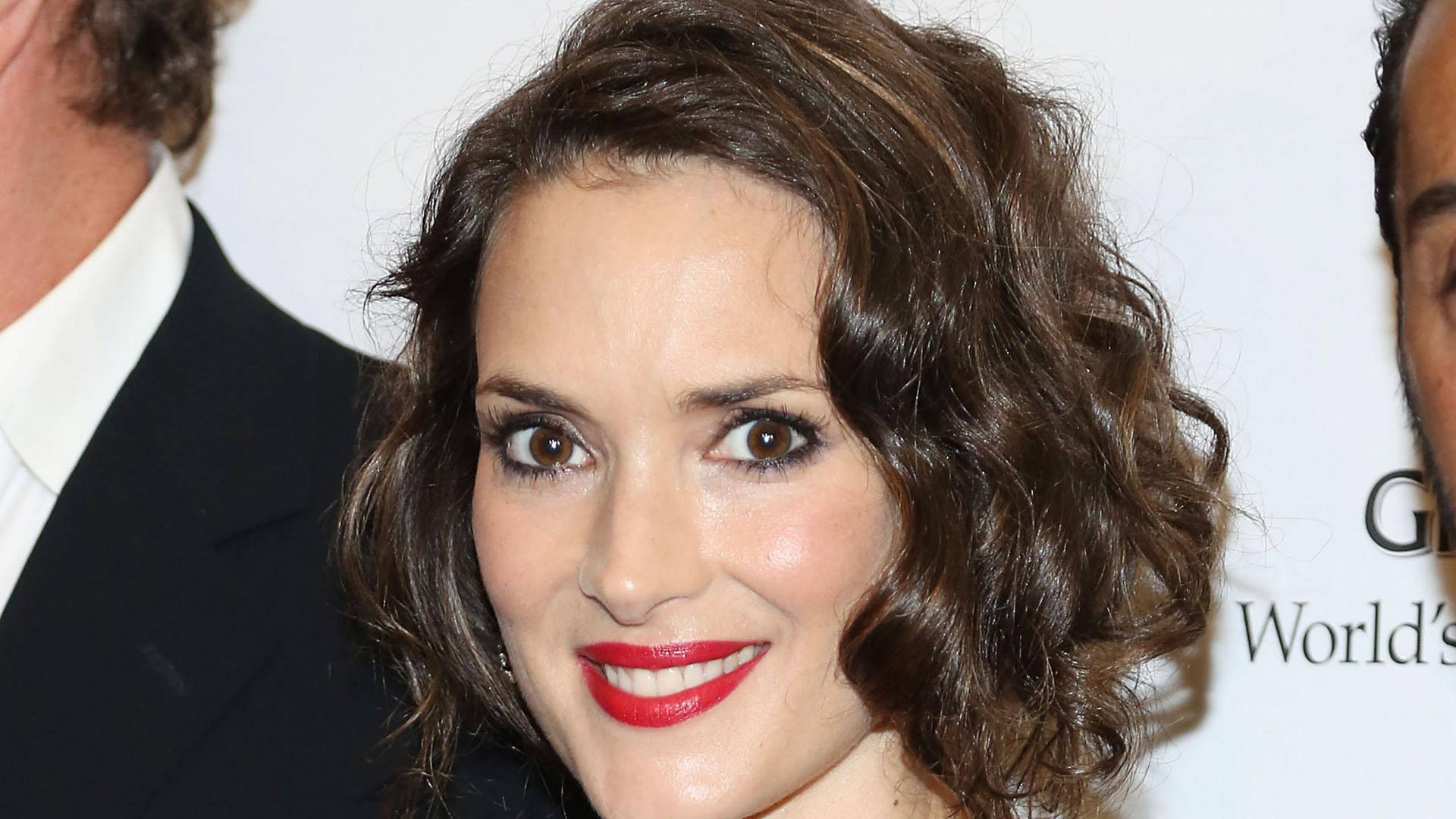 Stunning Winona Ryder Sporting Red Lipstick And A Curly Short Hairdo Background