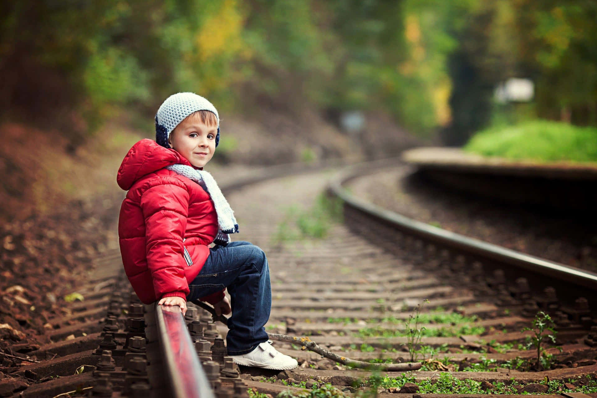 Stylish Boy Sitting On Railroad Background