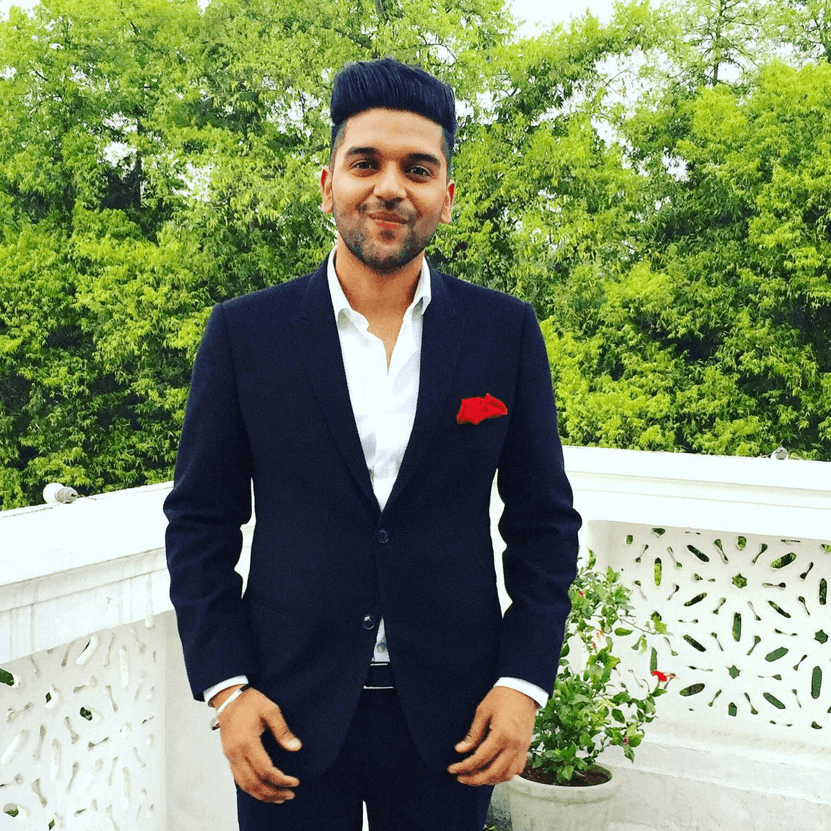 Stylish Guru Randhawa In Black Suit Background