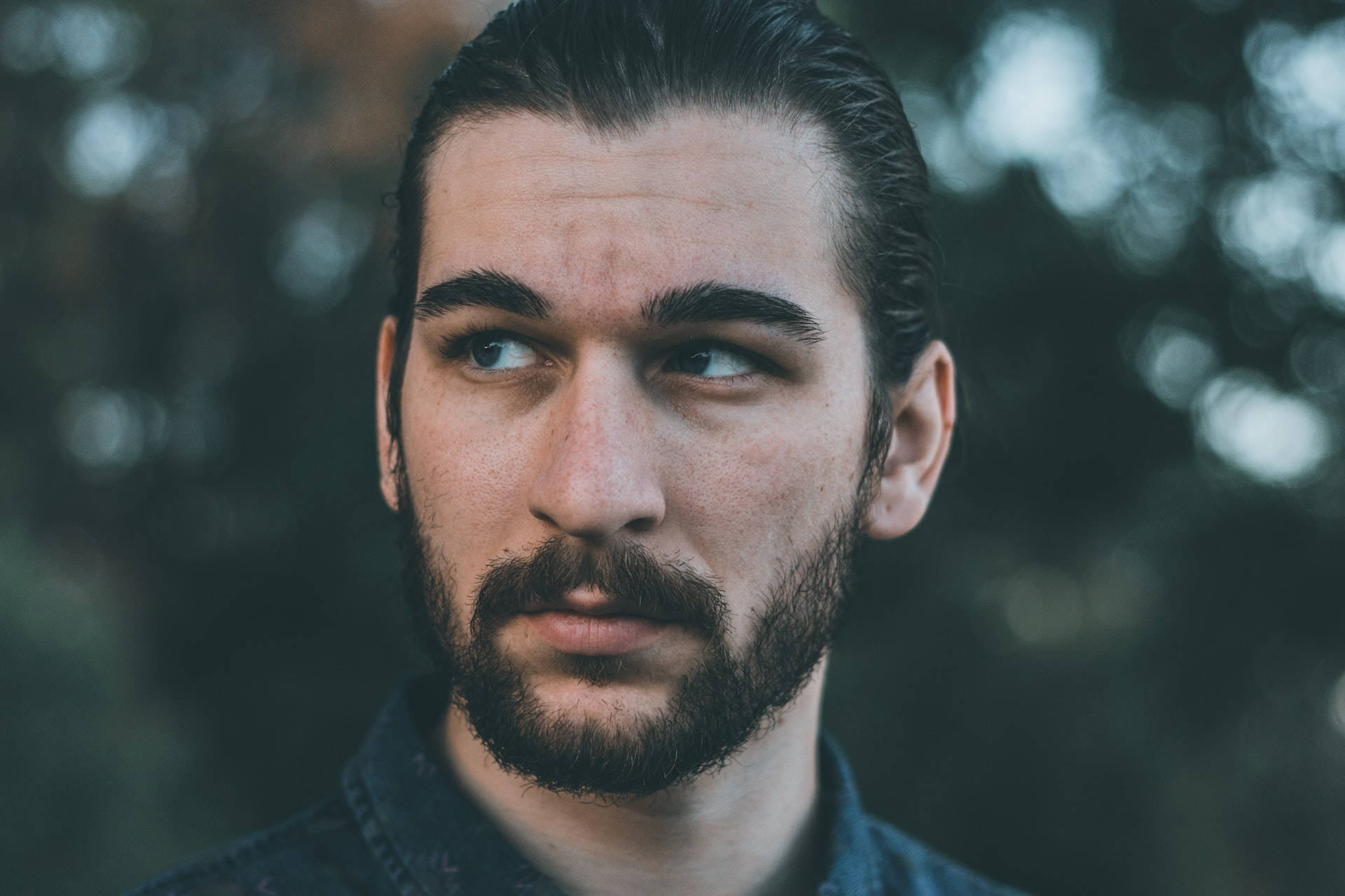 Stylish Man With A Sleek Pulled-back Haircut Background