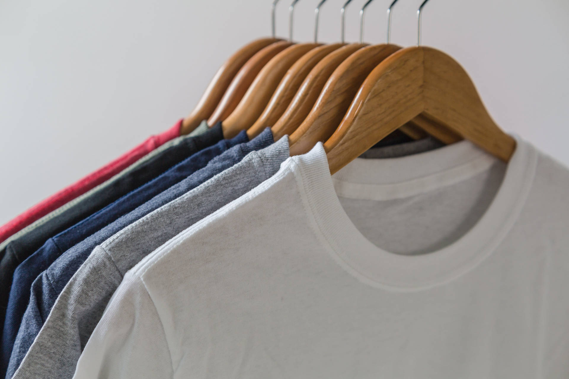 Stylish Plain Shirts Hanging In Row Background