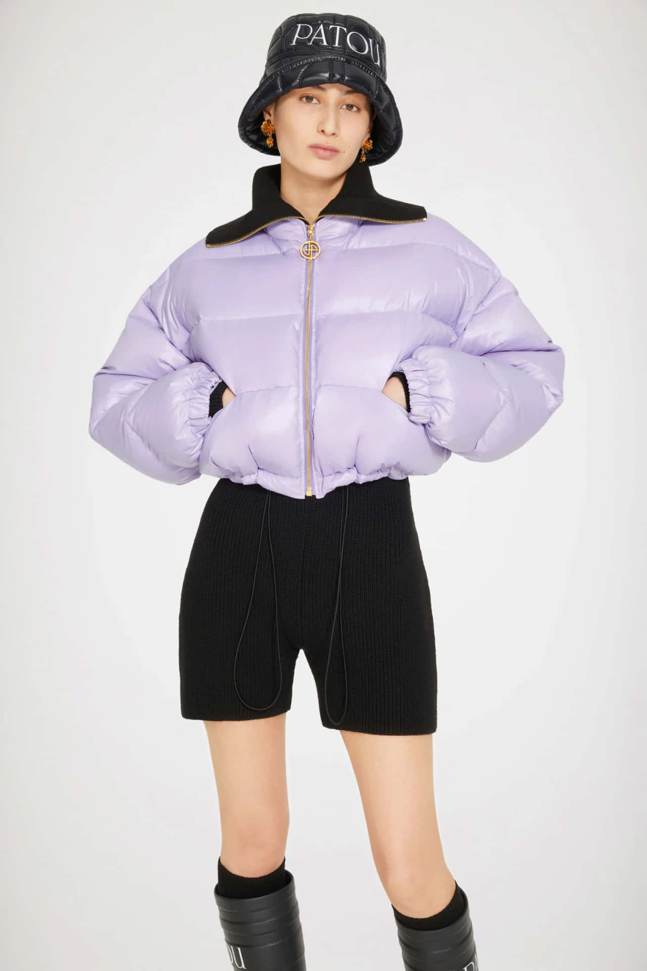 Stylish Woman In A Patou Purple Puffer Jacket Background