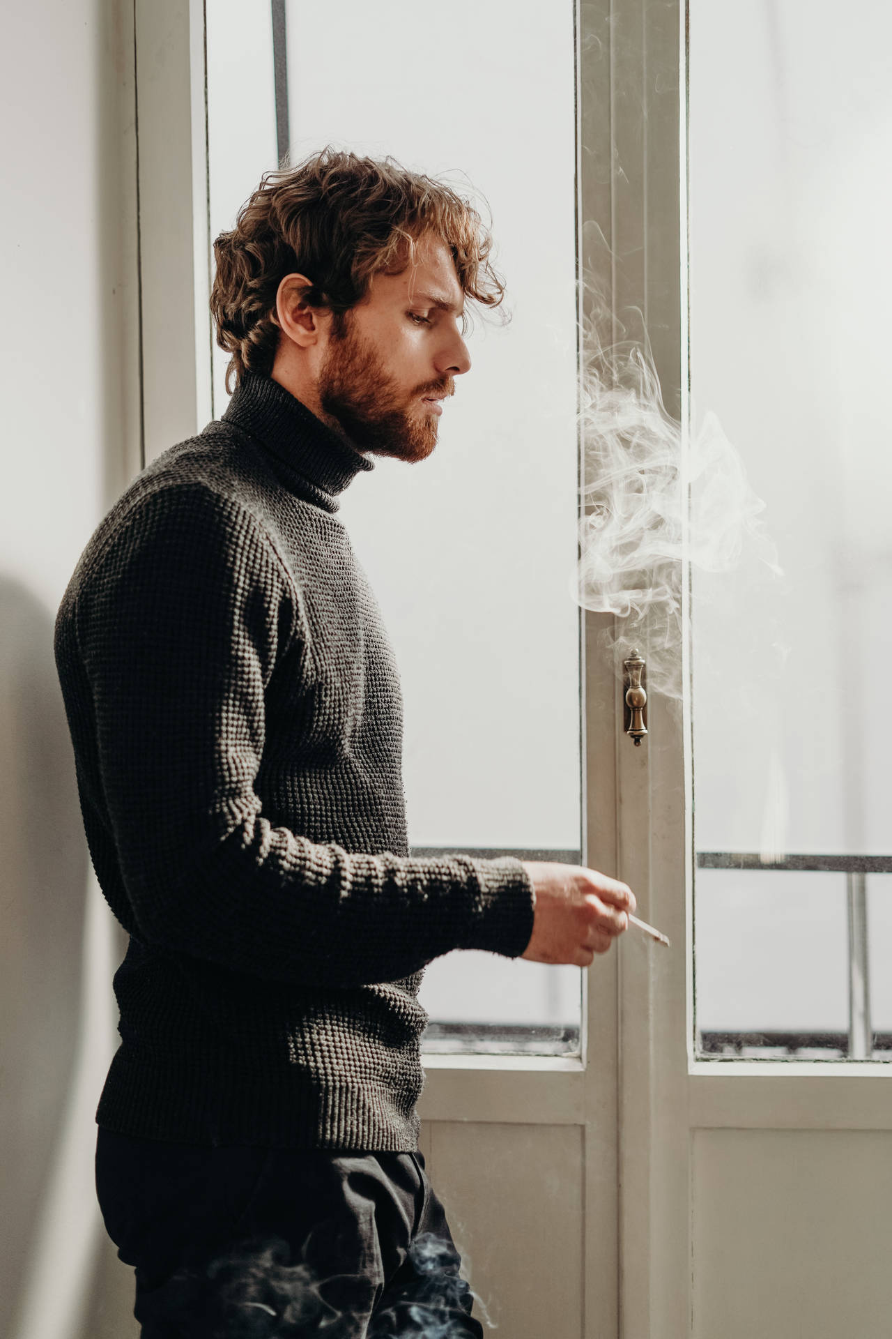 Stylishly Rugged Man Enjoying A Cigar Background