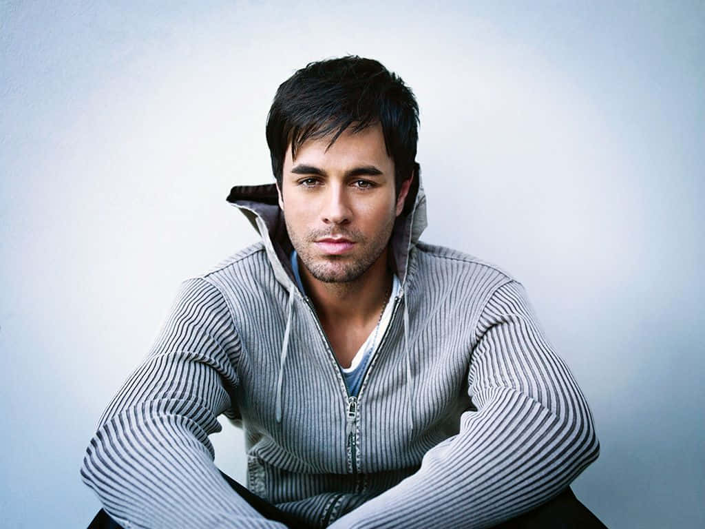 Suave Enrique Iglesias Sitting [wallpaper] Background
