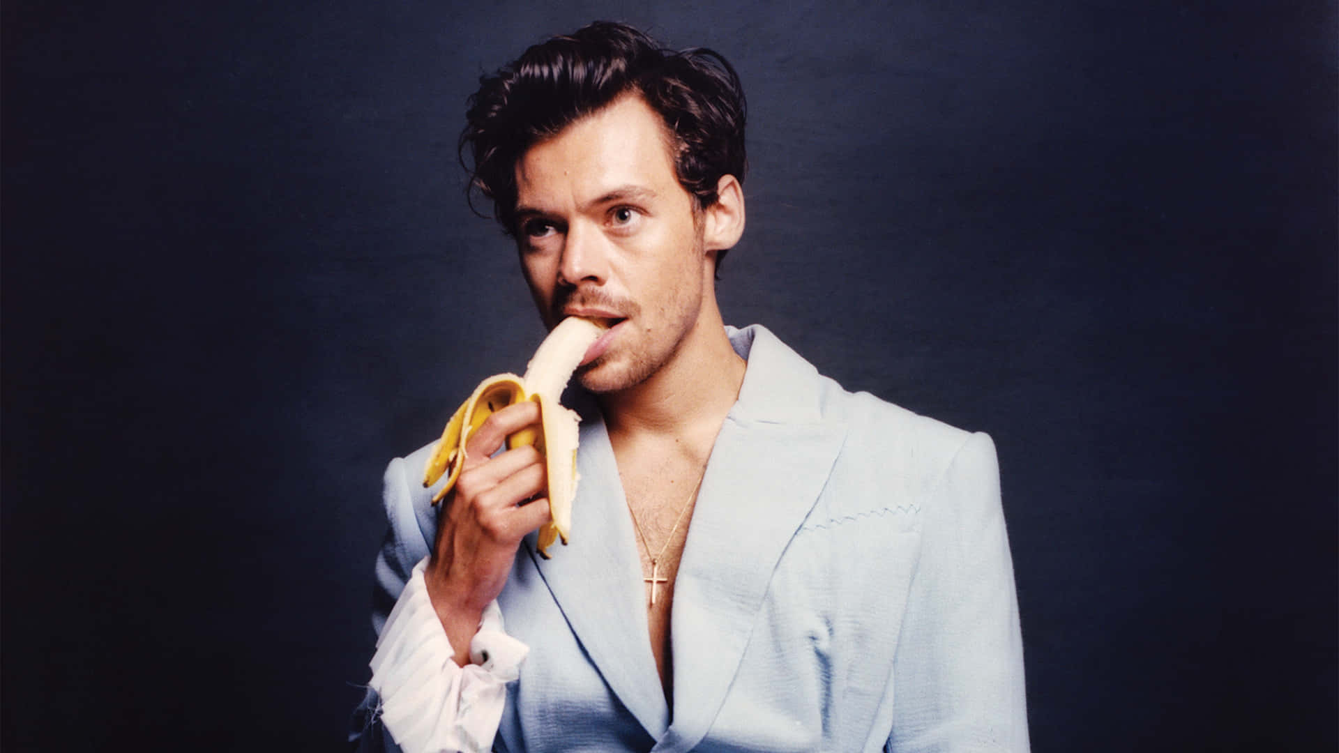 Suave Harry Styles Eating Banana [wallpaper] Background
