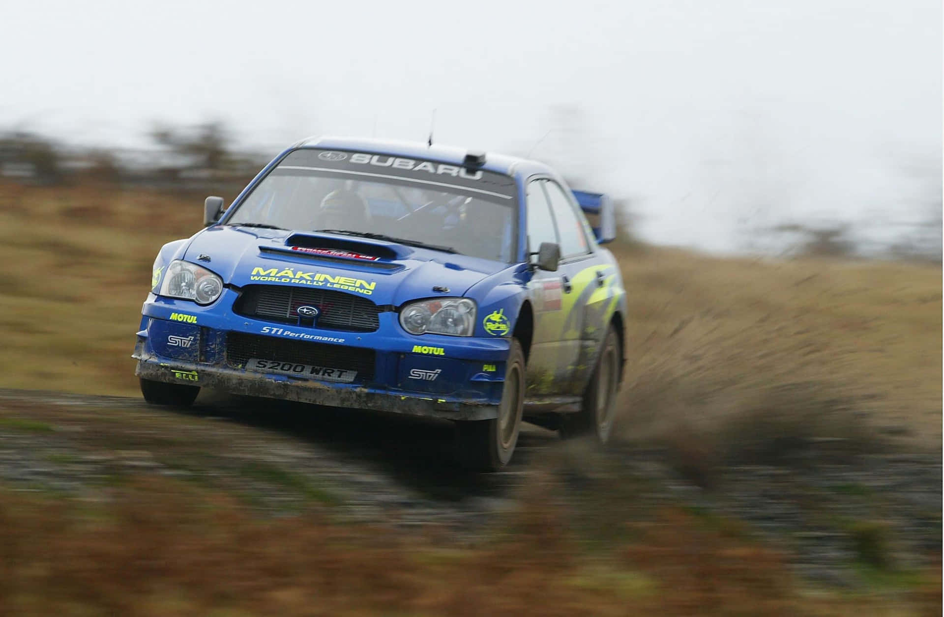 Subaru Rally Car Speeding Through Field Background