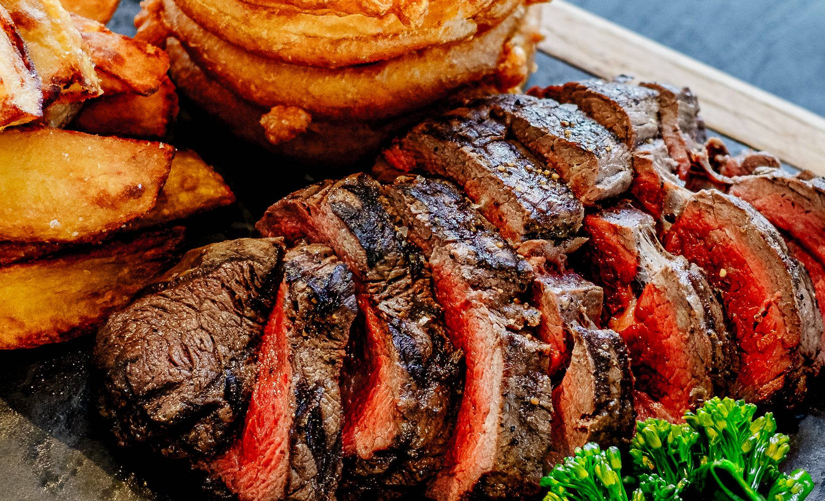 Succulent Medium-rare Steak Sizzled On A Parrilla Background