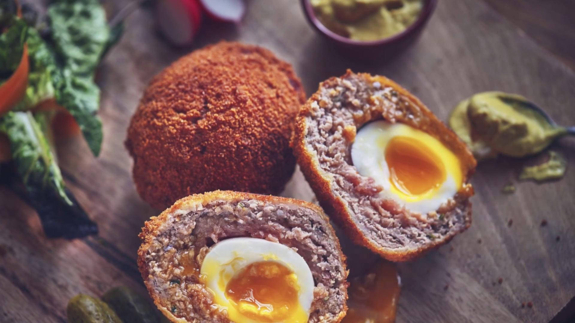 Succulent Traditional British Scotch Eggs Garnished With Fresh Green Spinach Background