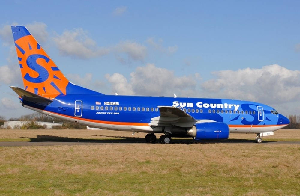 Sun Country Aircraft With Orange Logo Background