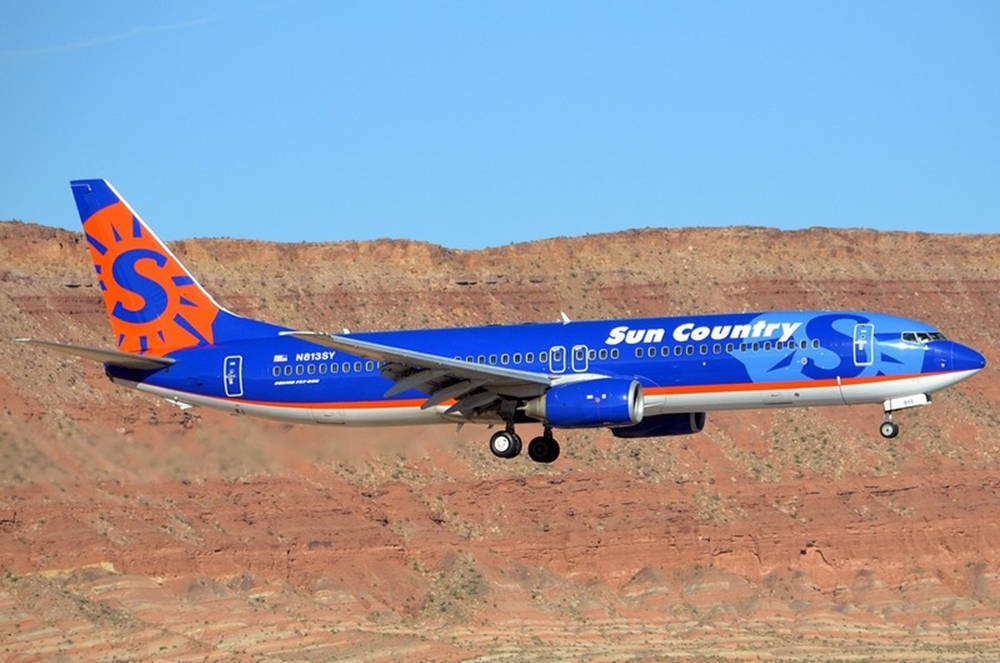 Sun Country Airplane Above Canyon Background