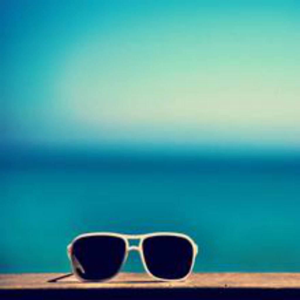 Sunglasses On A Wooden Deck With The Ocean In The Background Background