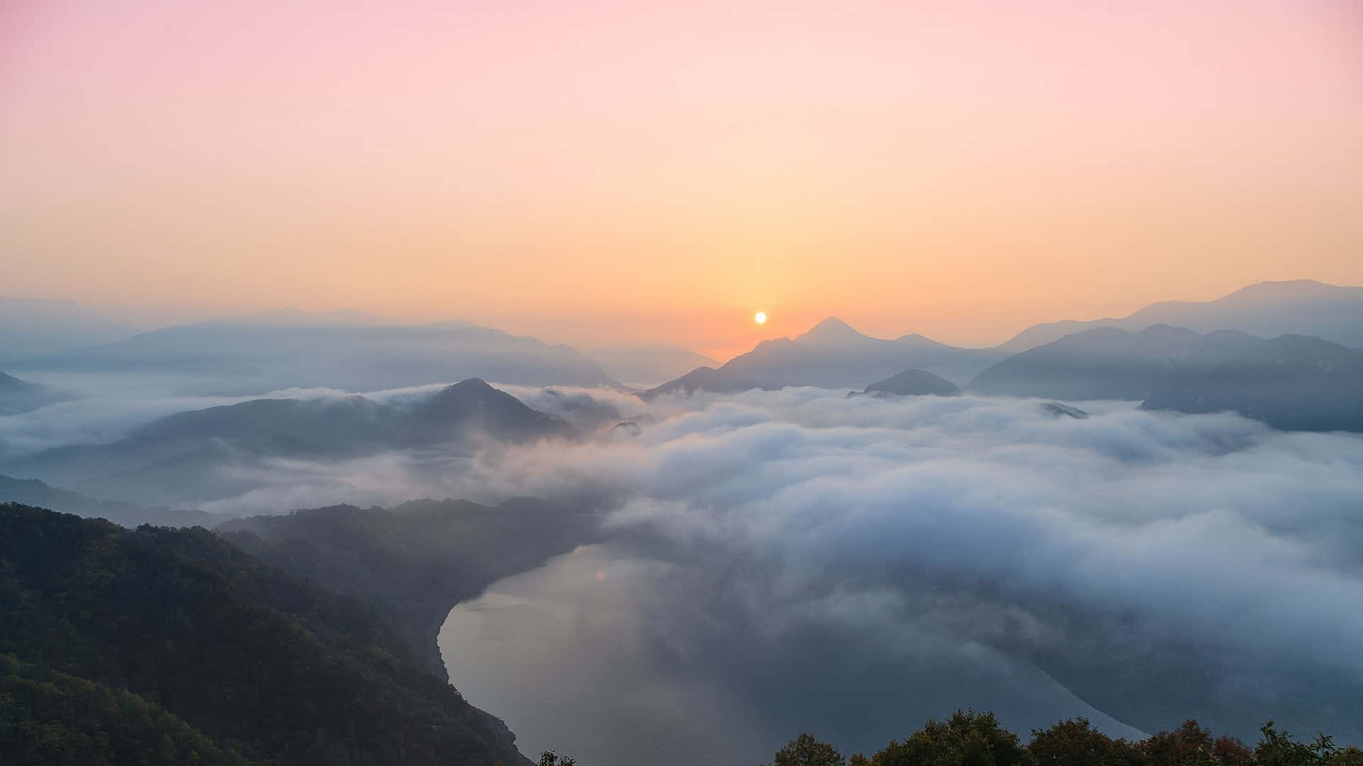 Sunrise Over A Lake With Clouds In The Background