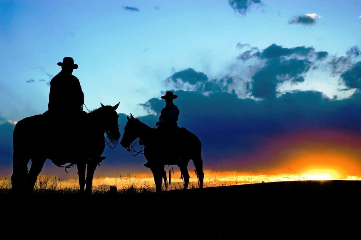 Sunset And Silhouettes Of Western Cowboys Desktop Background