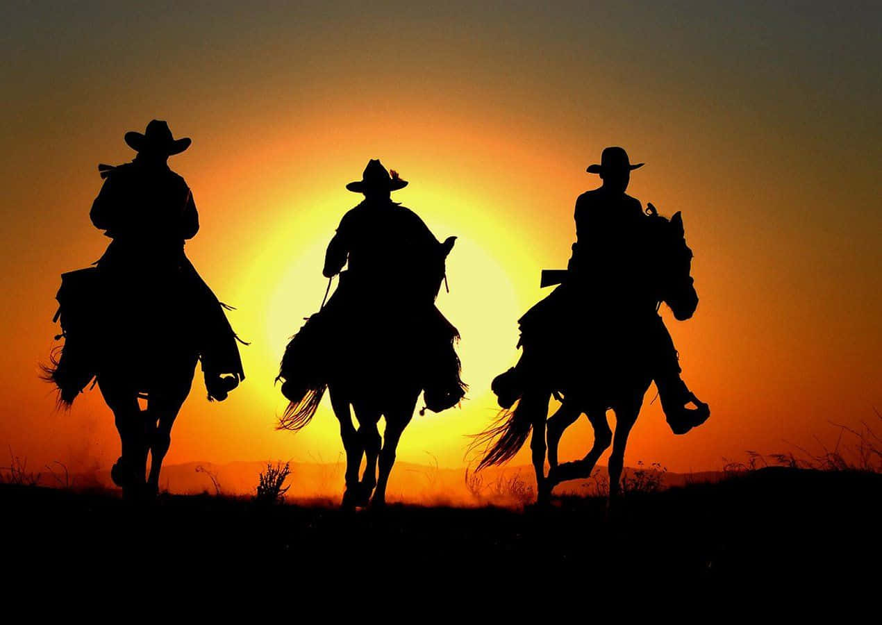 Sunset Silhouettes Of Three Western Cowboys Desktop Background