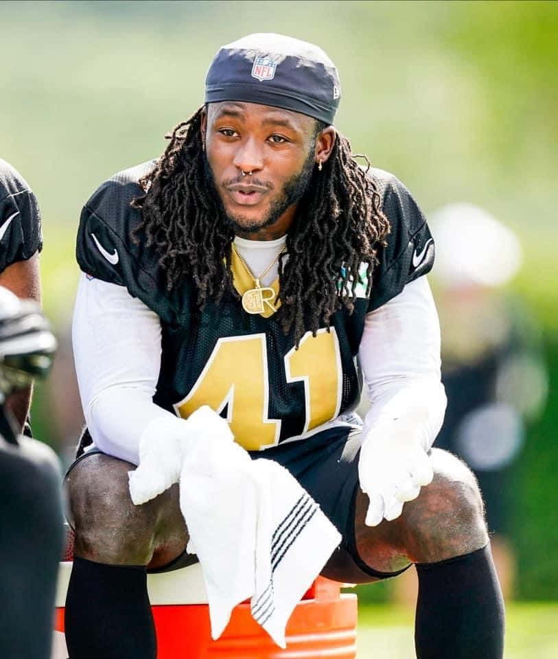 Super Bowl Champion Alvin Kamara Balancing Football And Fame Background