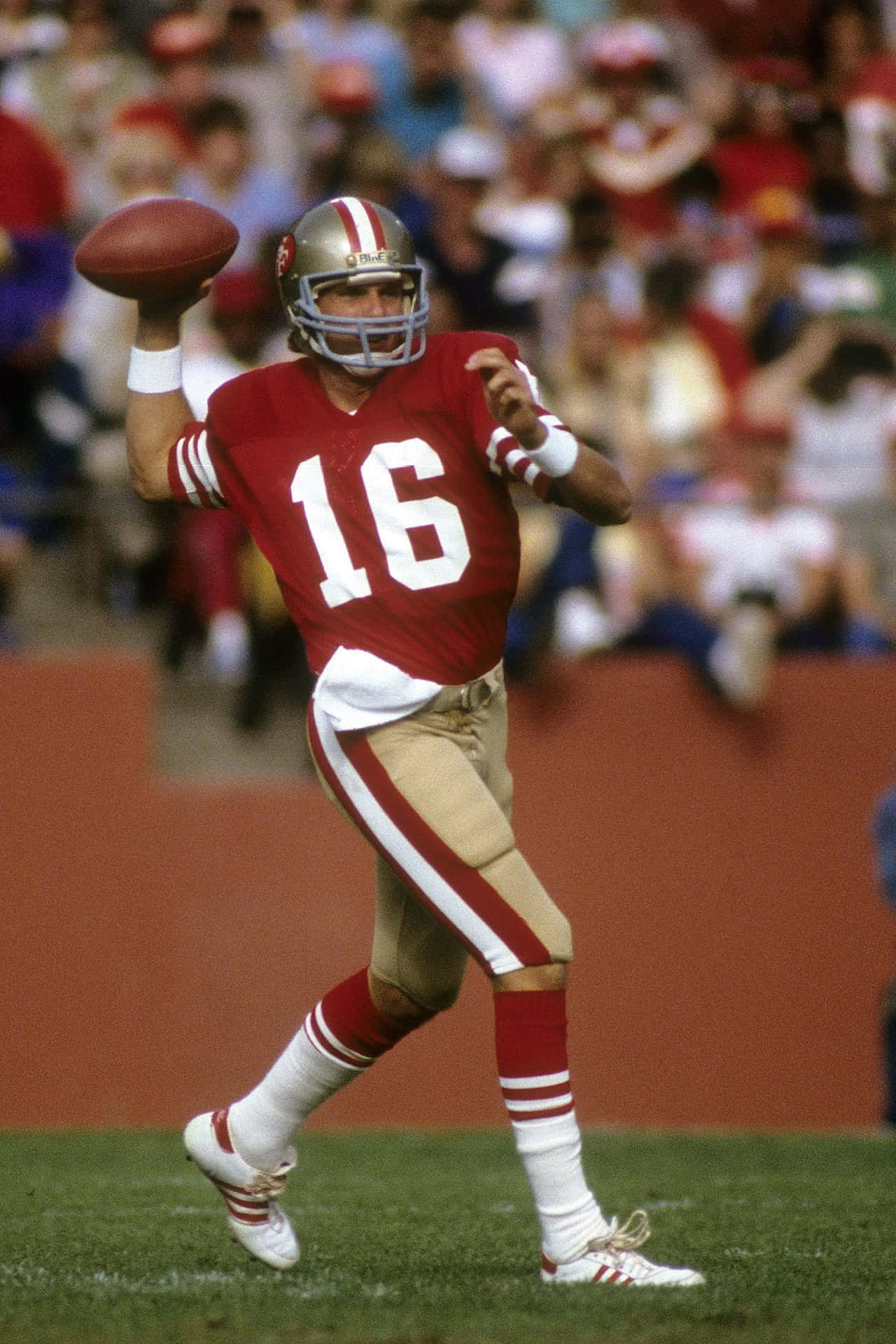 Super Bowl-winning Quarterback Joe Montana Leads The San Francisco 49ers Onto The Field In 1988 Background