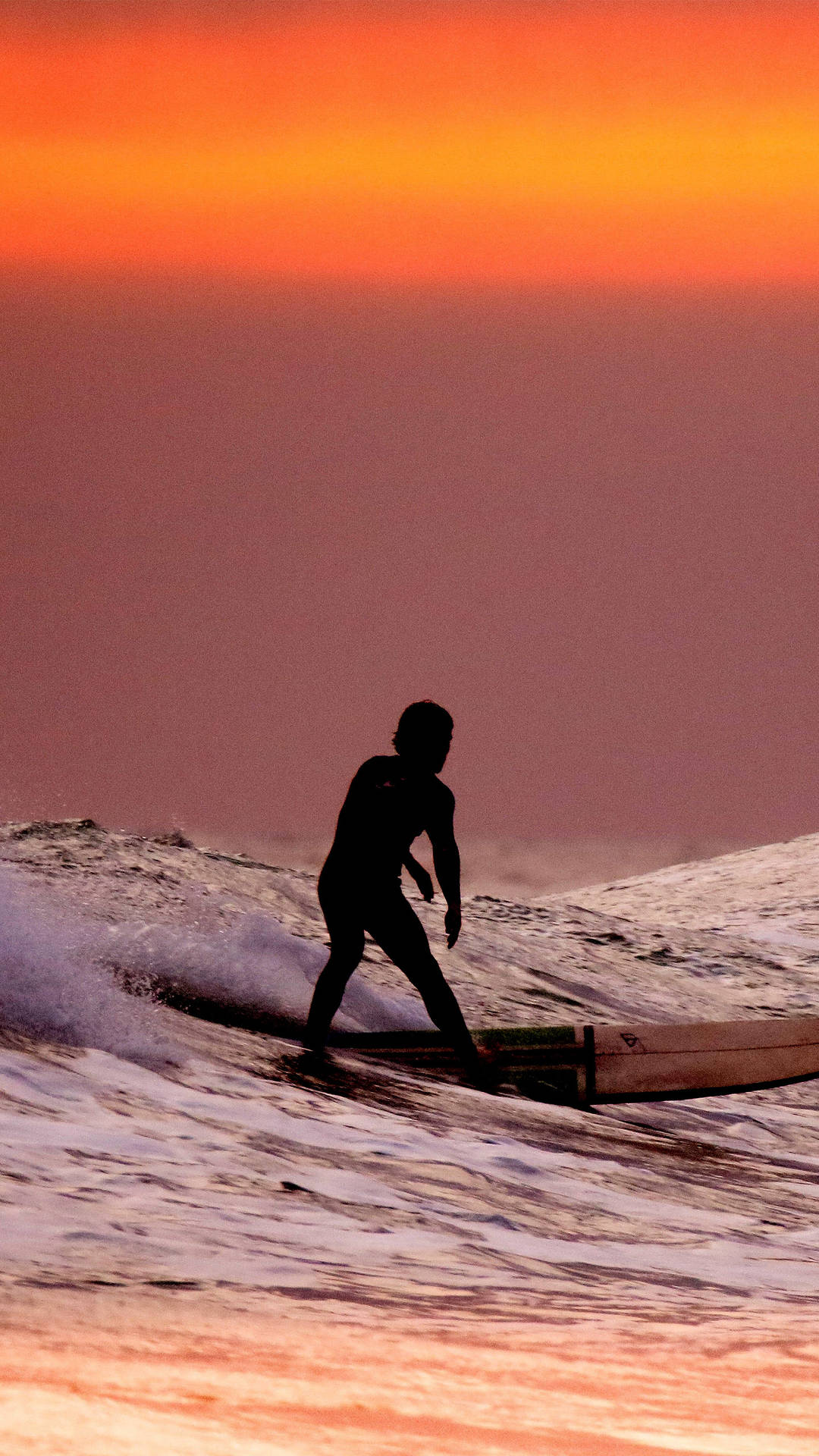 Surfing Under An Orange Sunset Sky