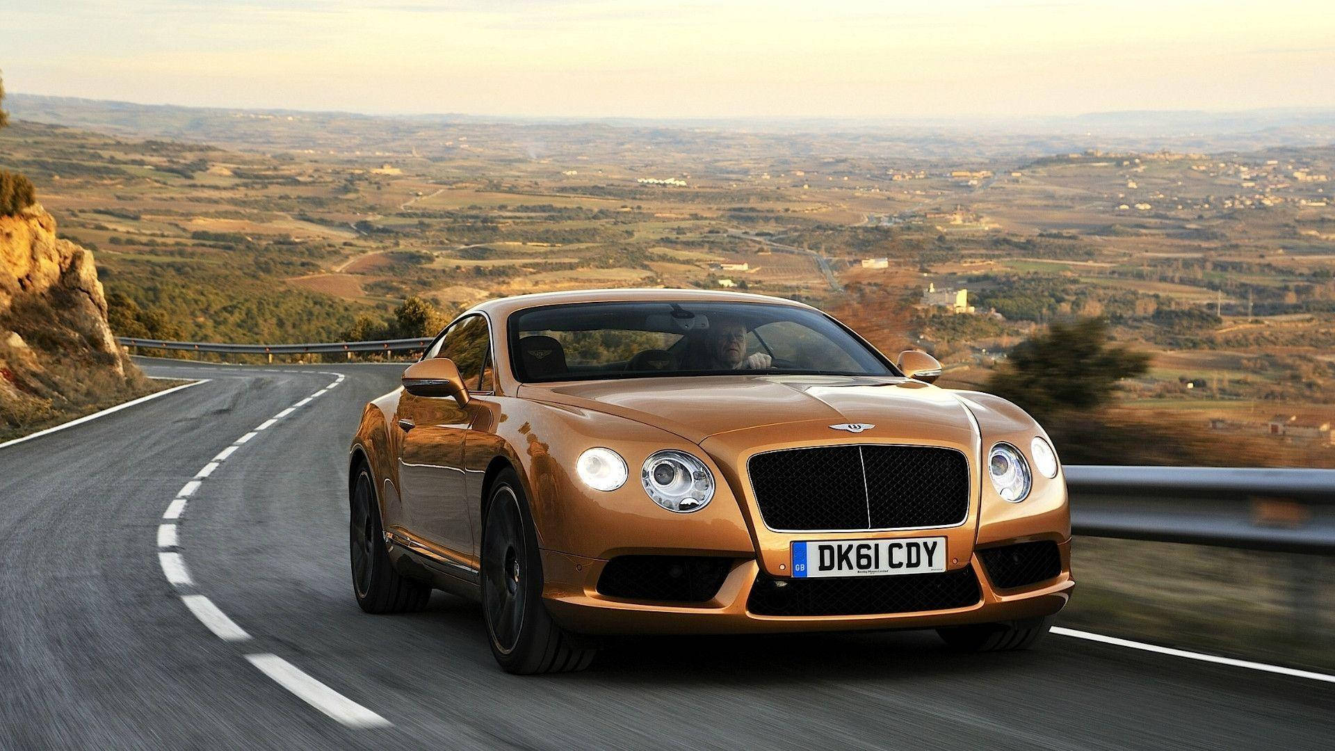 Sweeping Design - Bentley Continental Gt On The Road Background