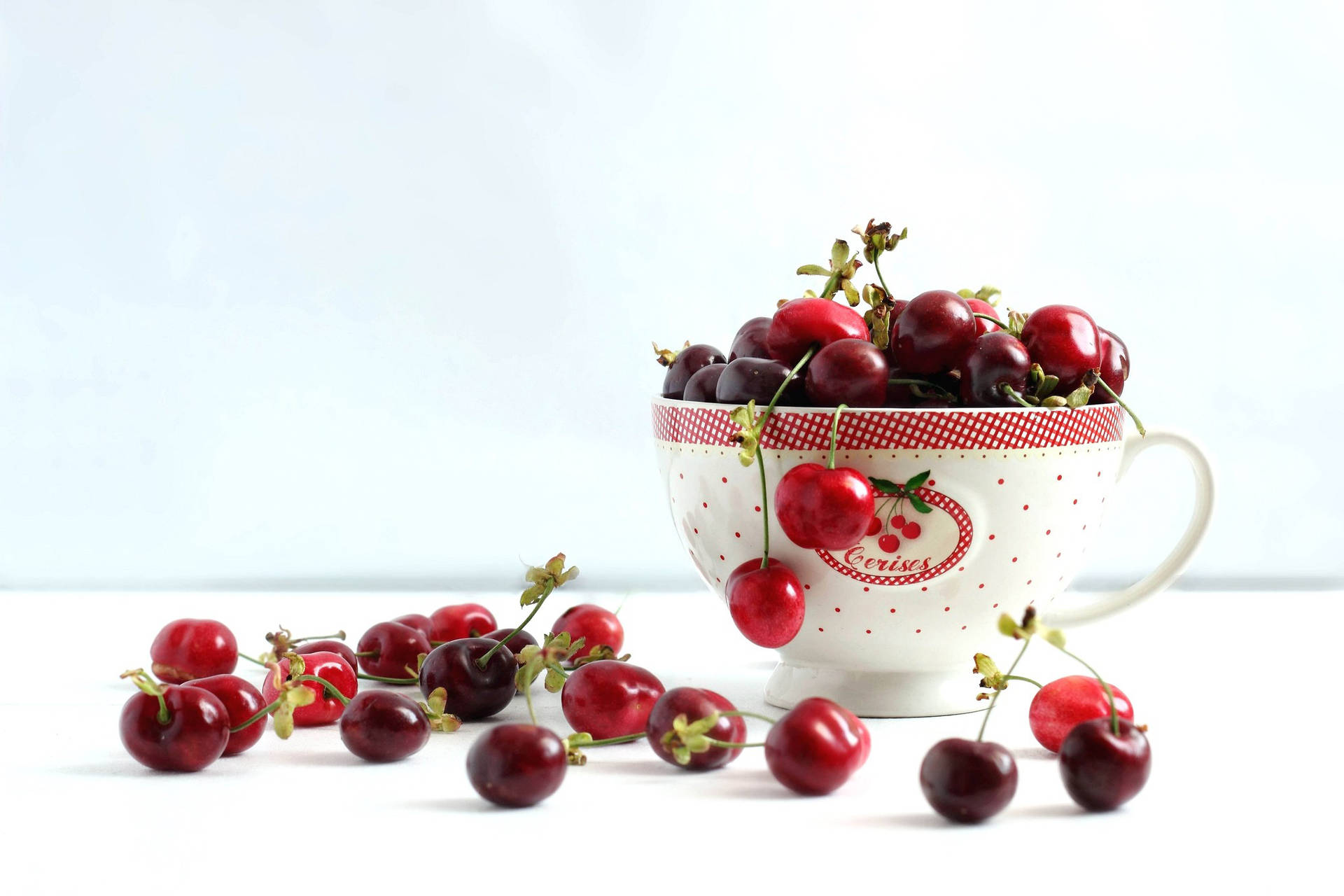Sweet Benton Cherries In A Teacup Background