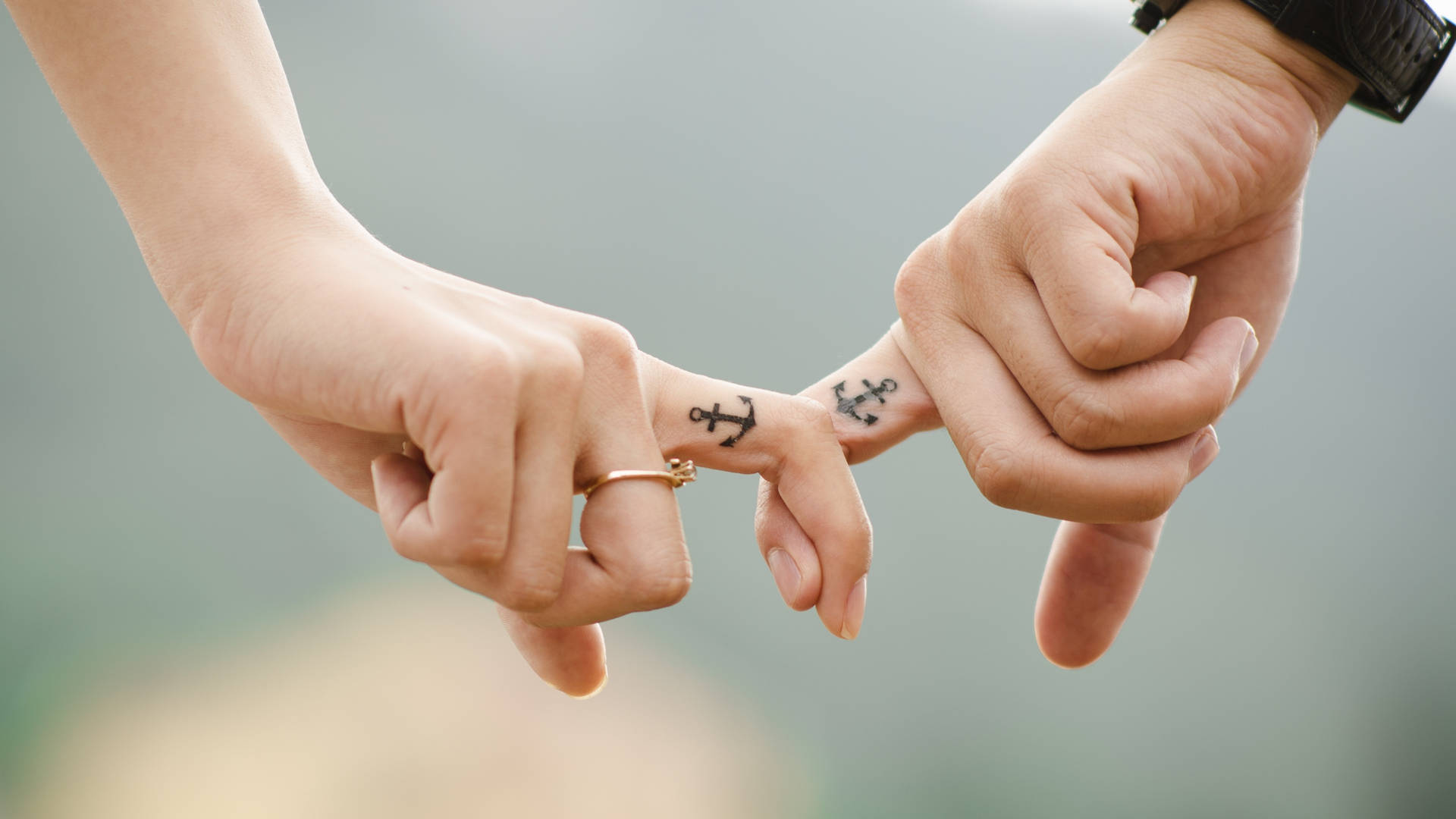 Sweet Holding Hands With Anchor Tattoos Background