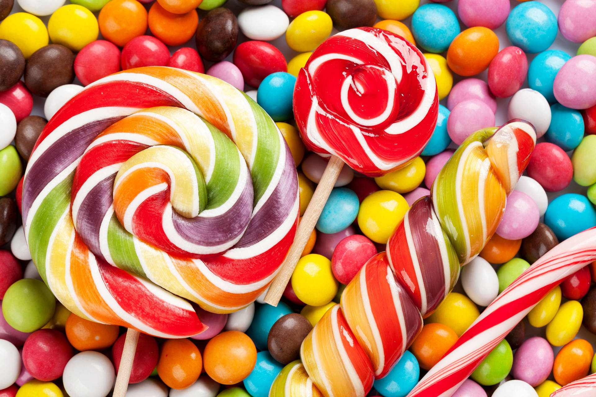 Swirly Lollipop And Round Candies Background