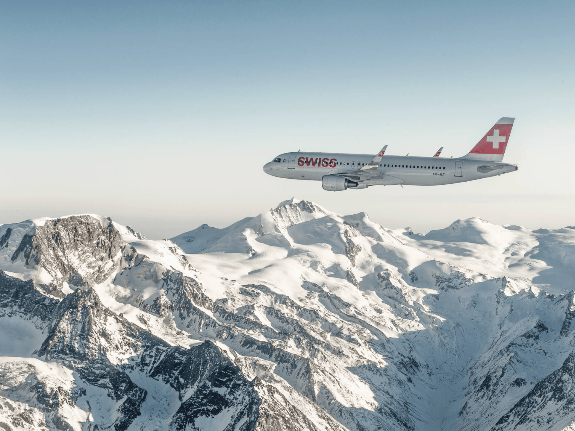 Swiss Airlines Aircraft Above The Snow Mountain Background