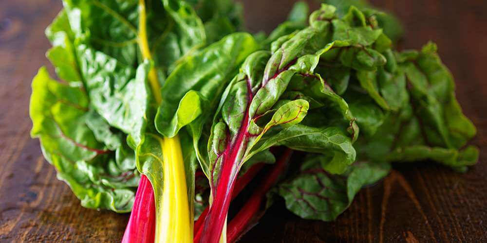 Swiss Chard Vegetables Atop Wooden Platform Background