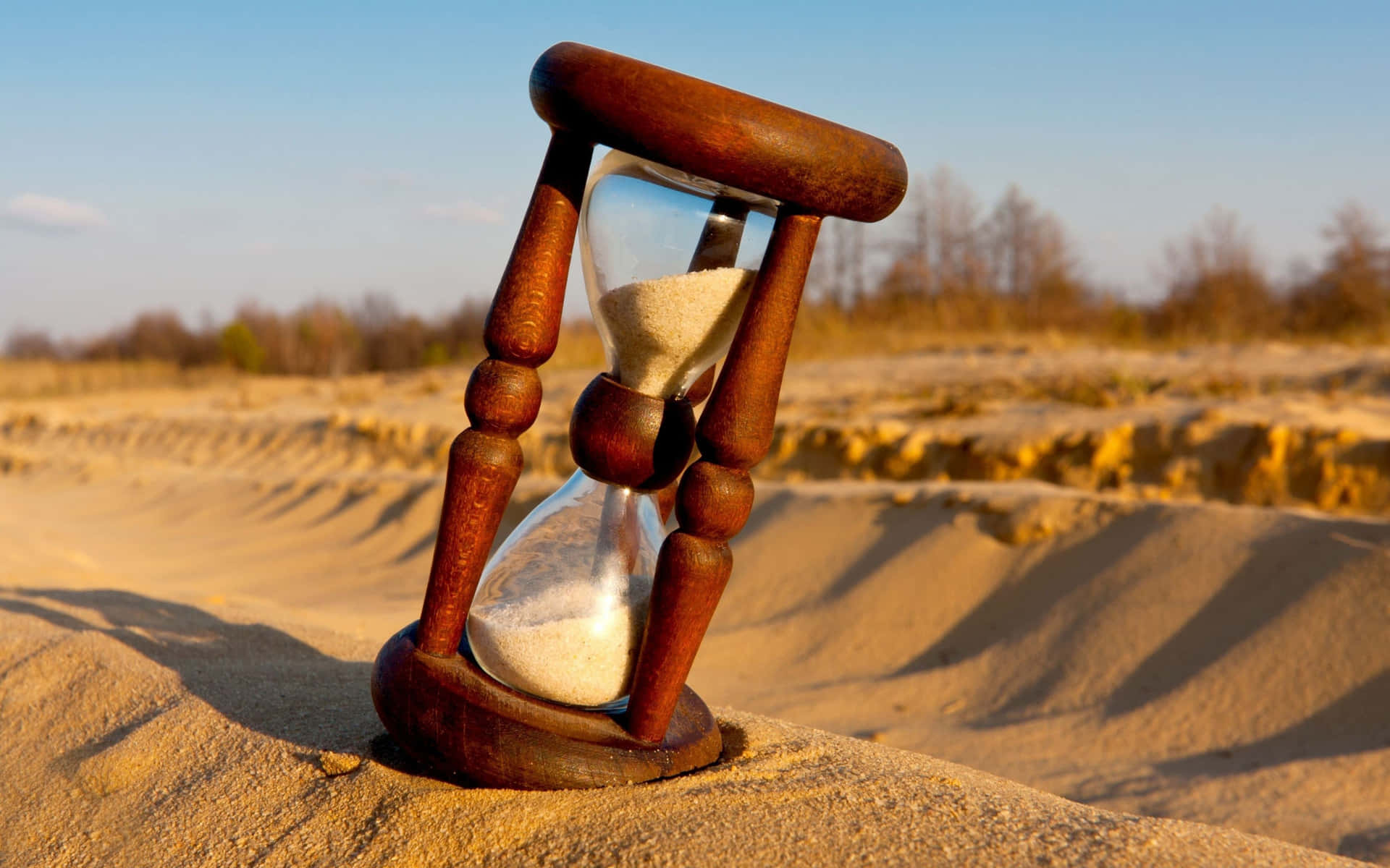 Symbolic Hourglass On Sand Background