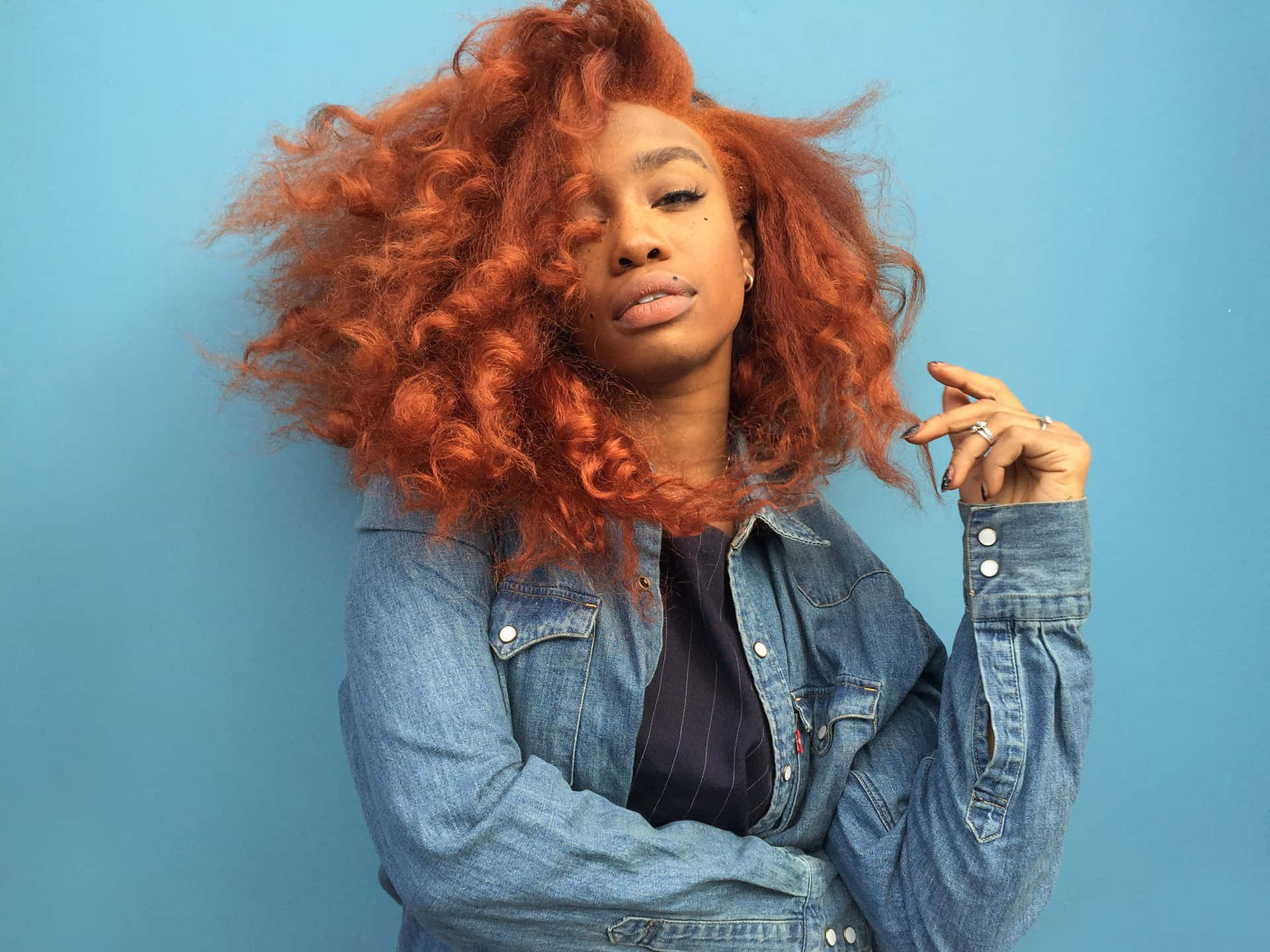 Sza In Her Iconic Persona With Blonde Hair, Sleek Outfit, And Gold Chains Background