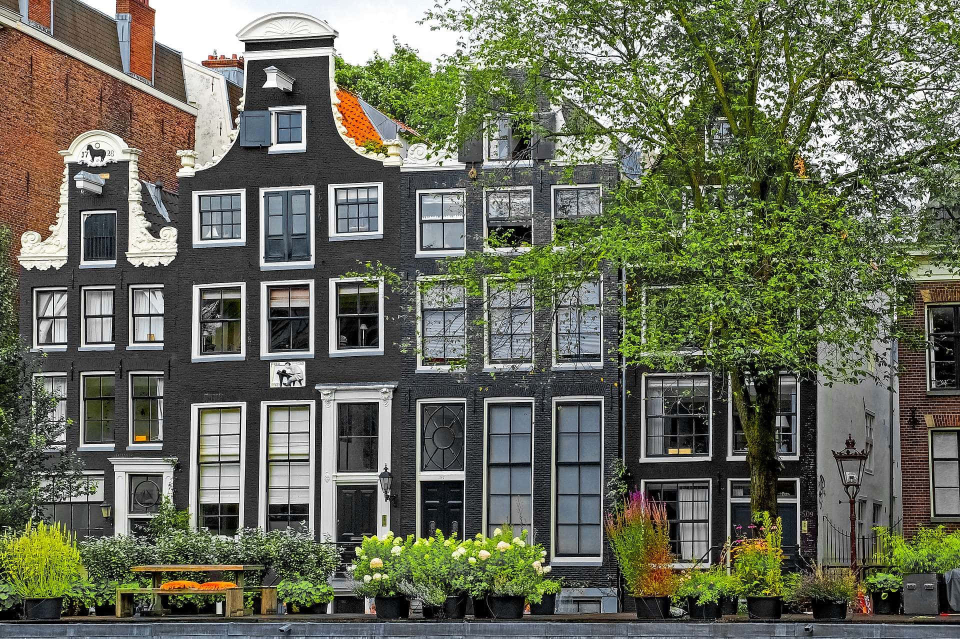 Take A Stroll Along The Canals Of Amsterdam In The Springtime Background