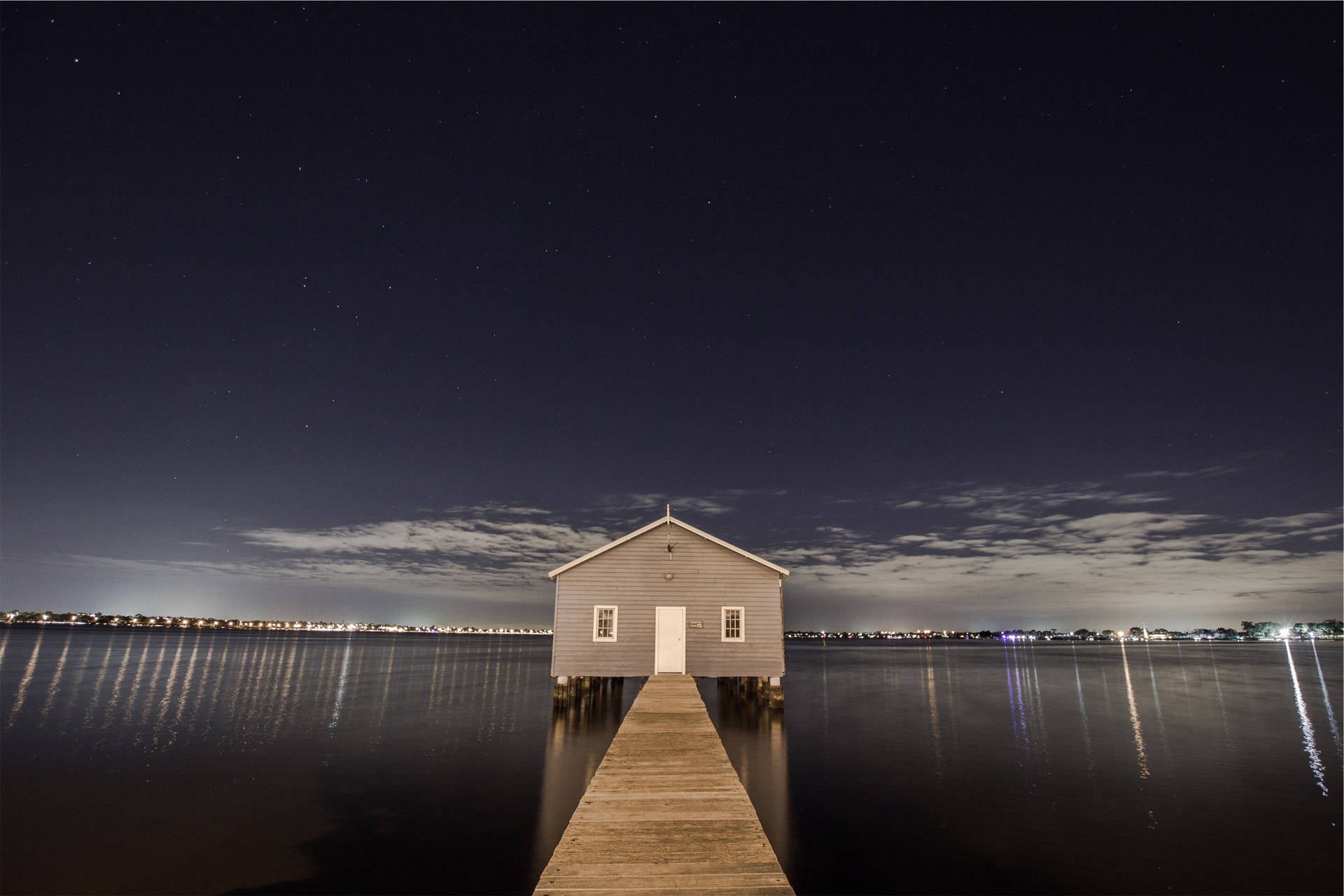 Take In The Beautiful View Of A House On A Tranquil Body Of Water.