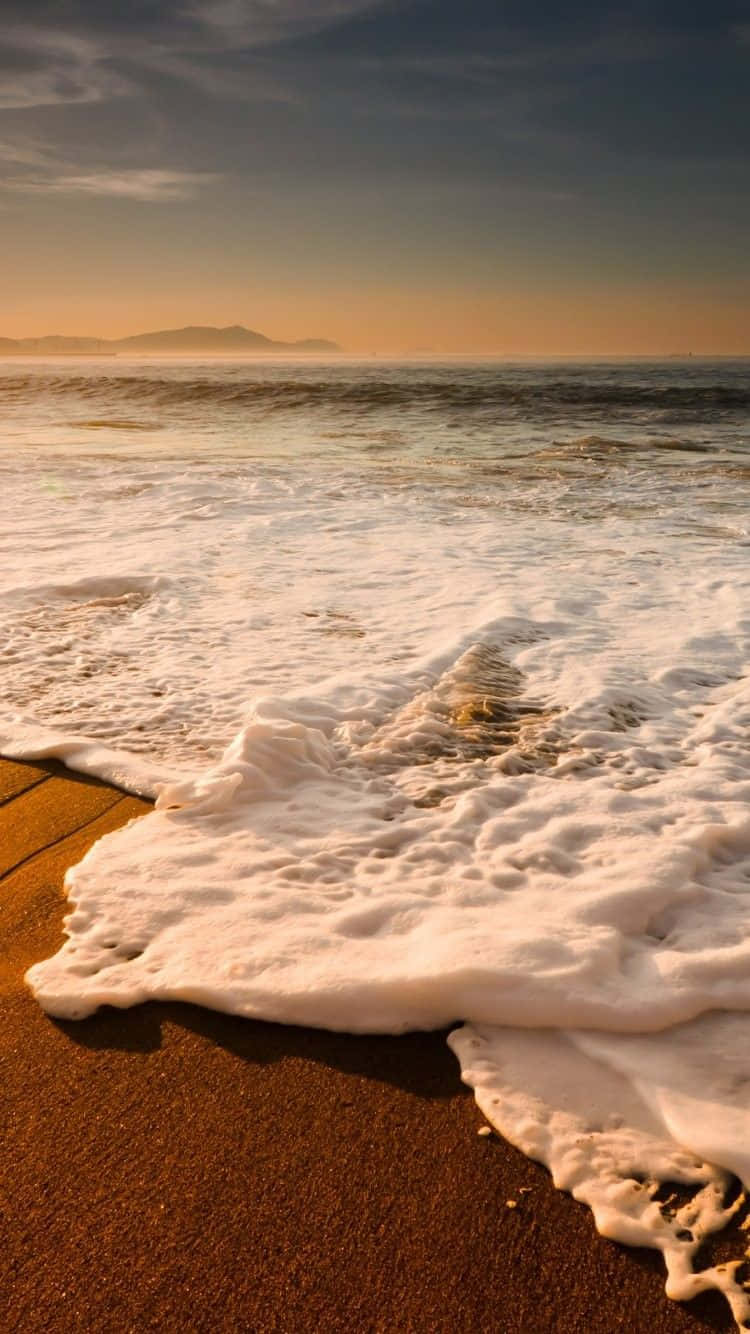 Take In The Beauty Of An Idyllic Sunset On The Beach With Your Iphone For An Unforgettable Moment. Background