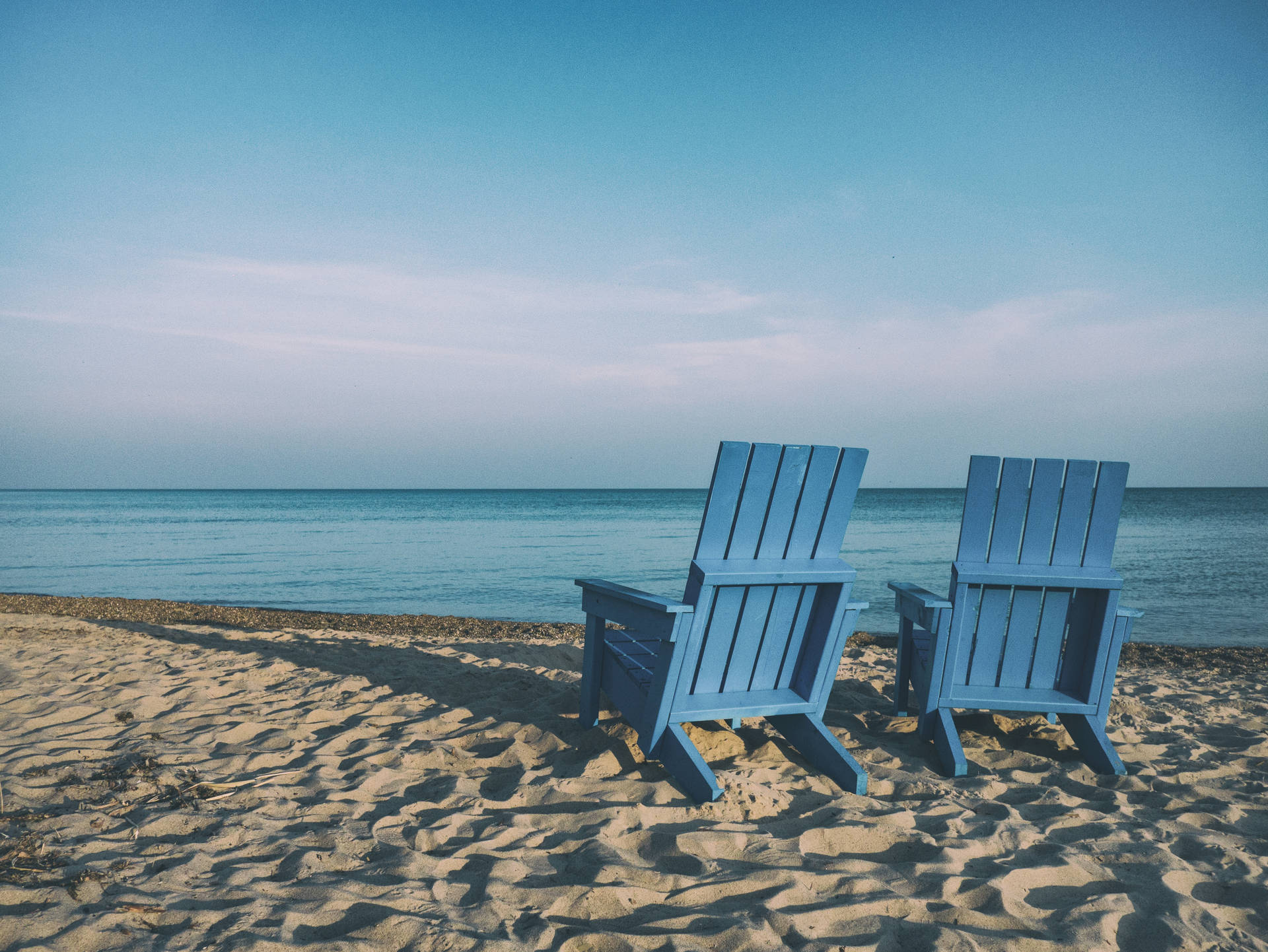 Take In The Ocean Views From The Comfort Of A Blue Beach Chair Background