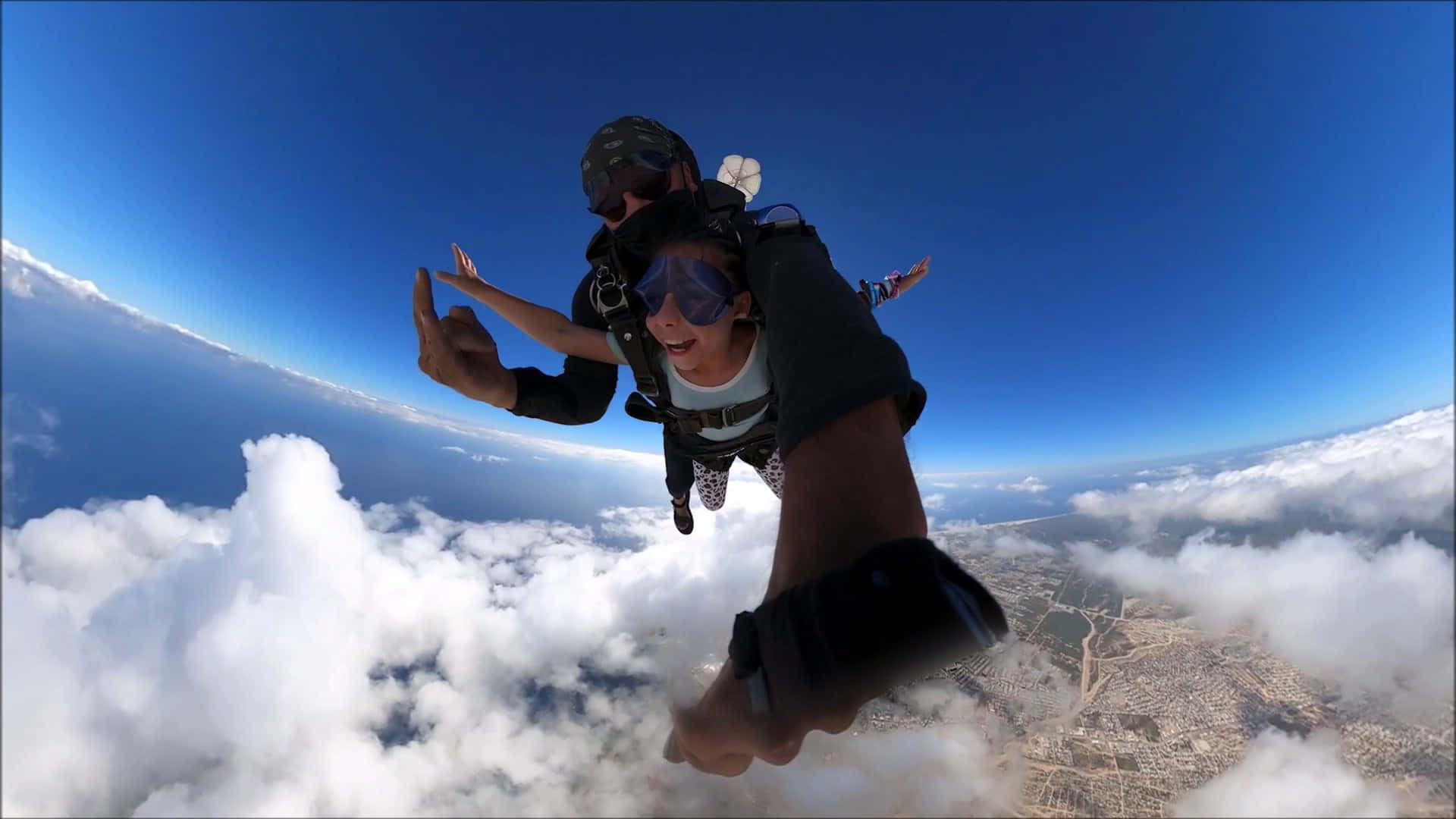 Tandem Skydiving Above Clouds Background