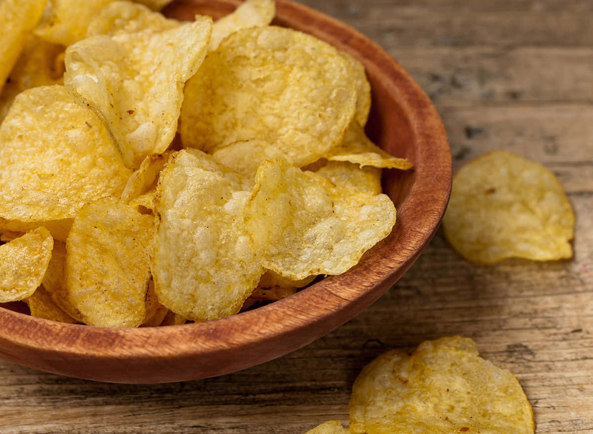 Tantalizing Crispy Potato Chips In A Ceramic Bowl Background