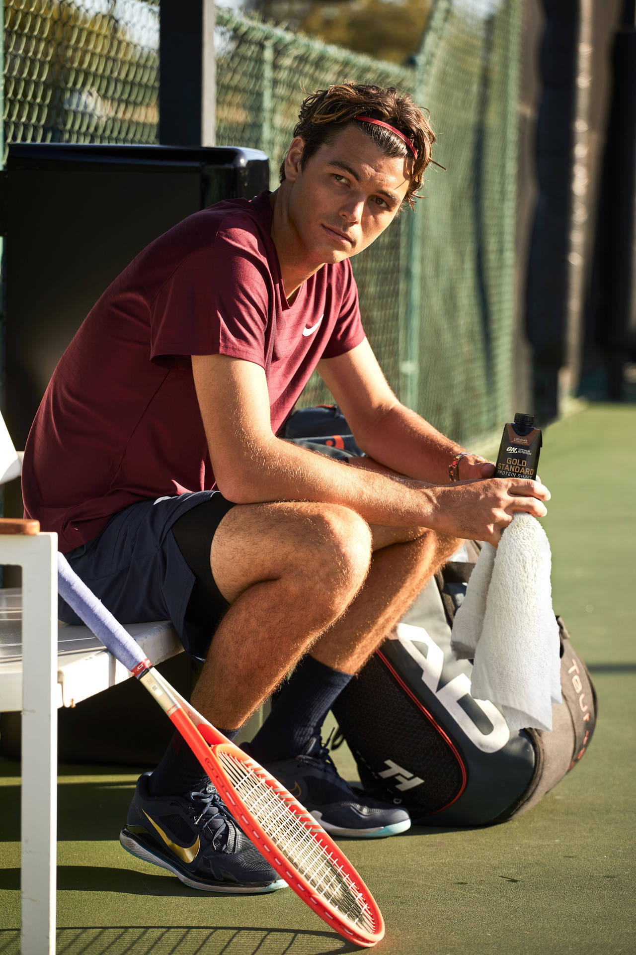 Taylor Fritz Sitting On A Bench Background