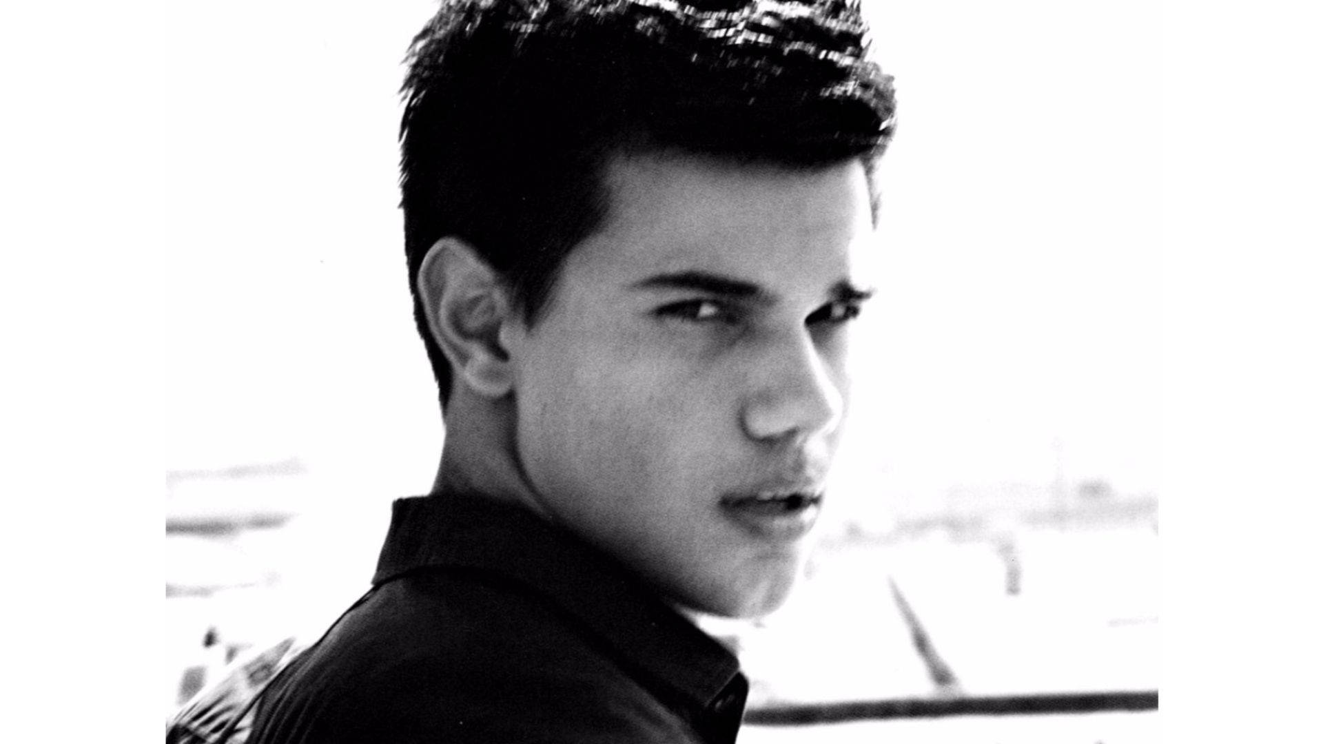 Taylor Lautner Looks Back Intensely Background