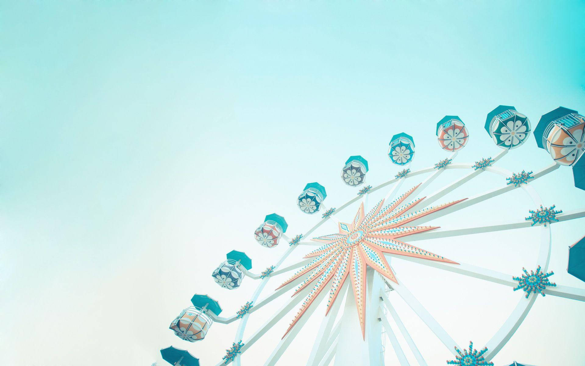 Teal Ferris Wheel Against Bright Sky Background