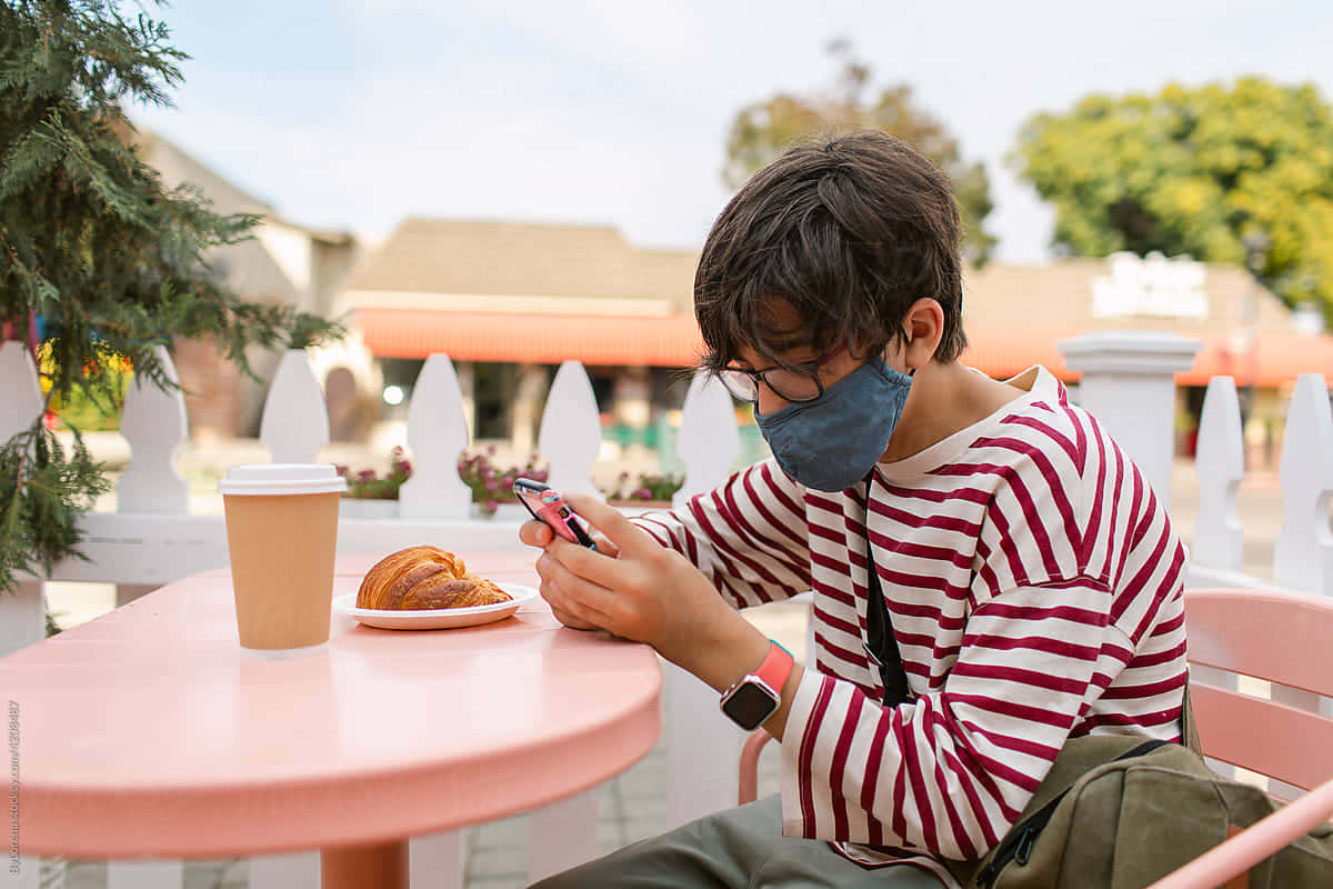 Teen Boy Using Smartphone Outdoors Background