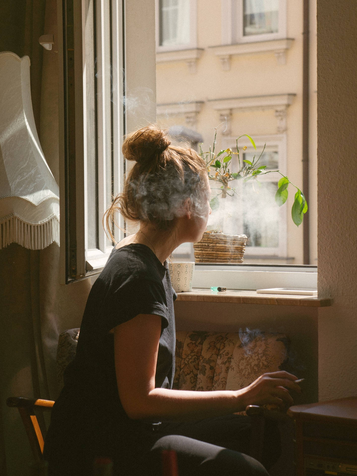 Teenage Girl Sitting And Smoking On A Window Background