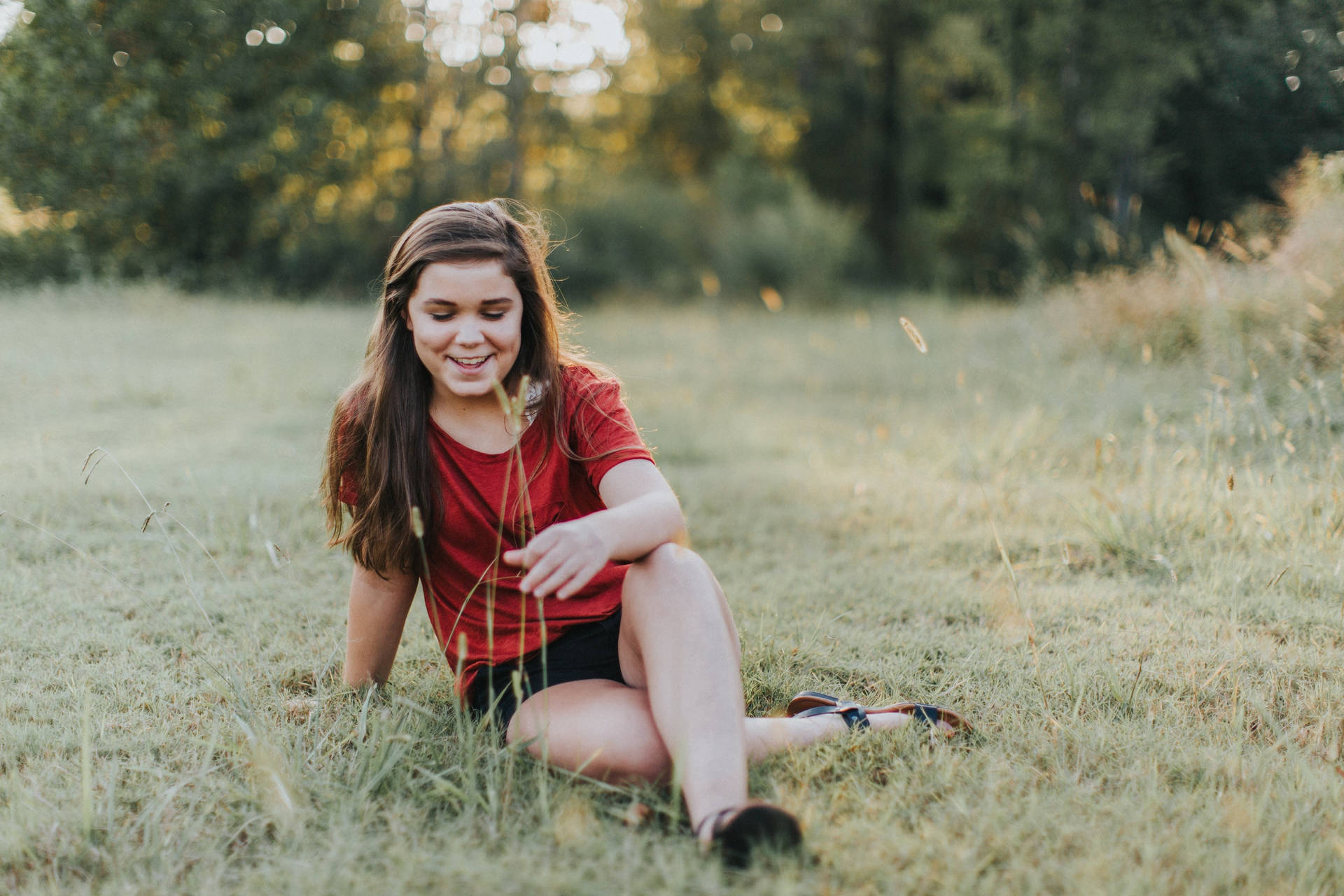 Teenage Girl Sitting On The Grass Background