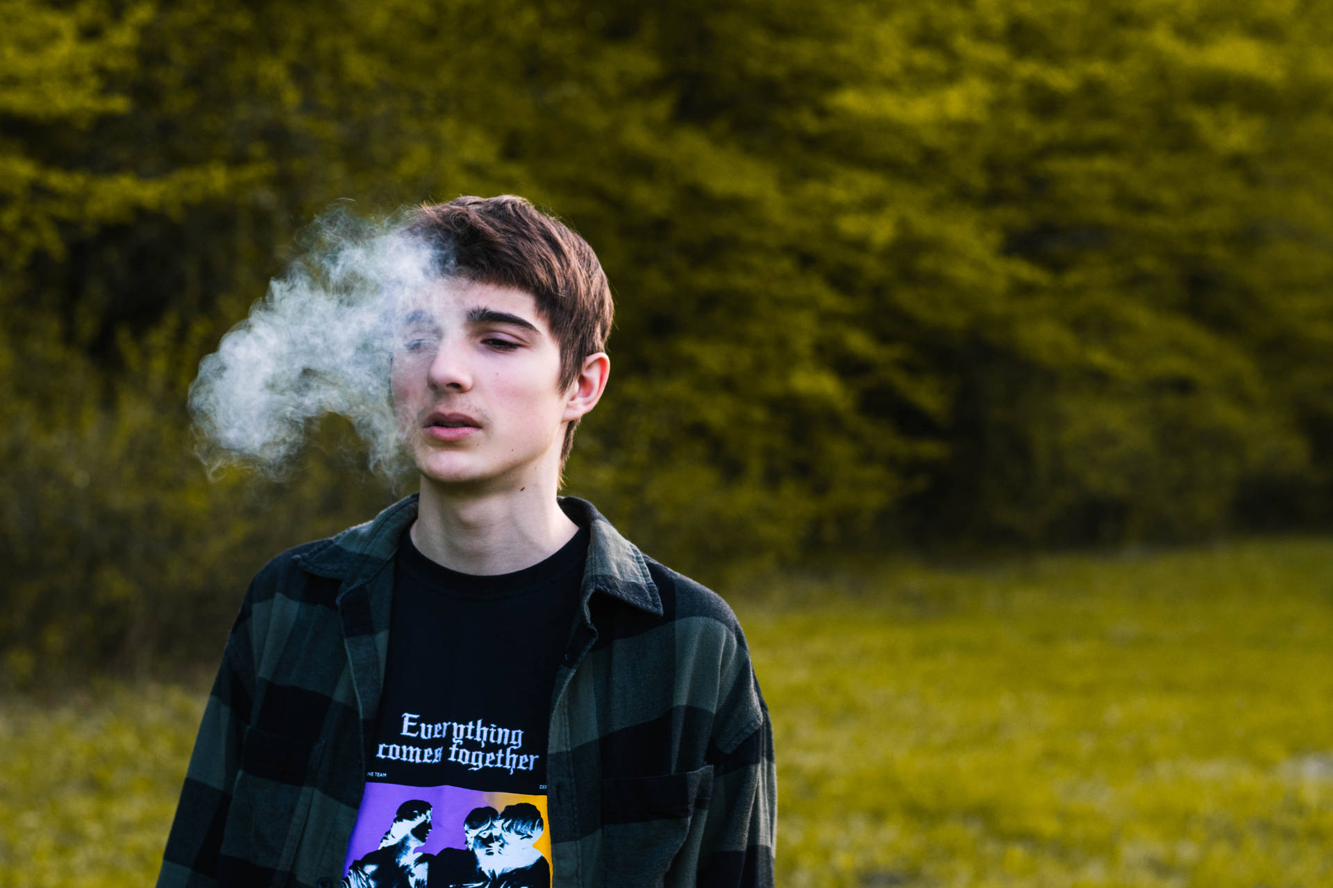 Teenage Guy Smoking In Park Background