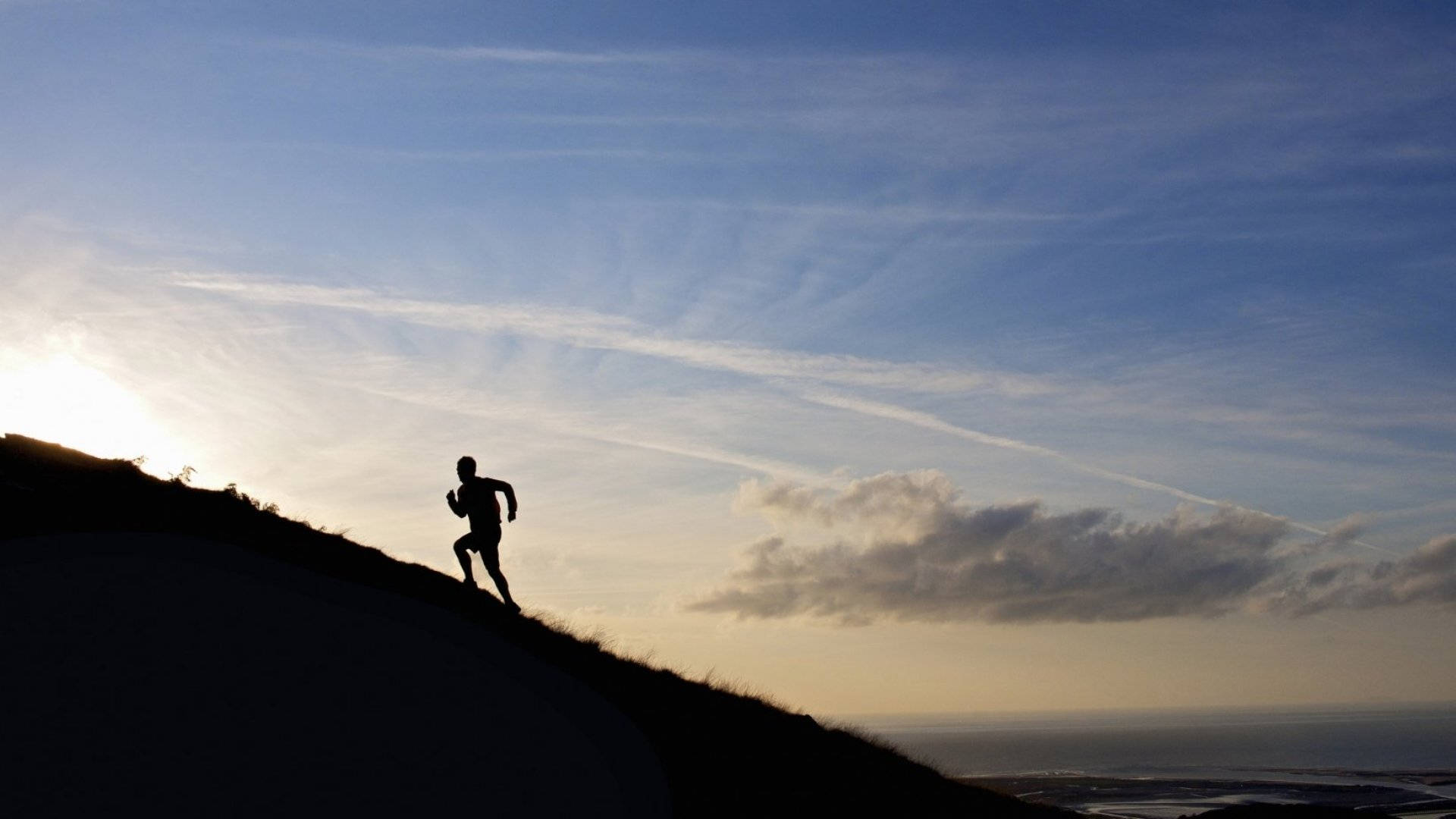 Tenacious Climbing Against Sunrise Background