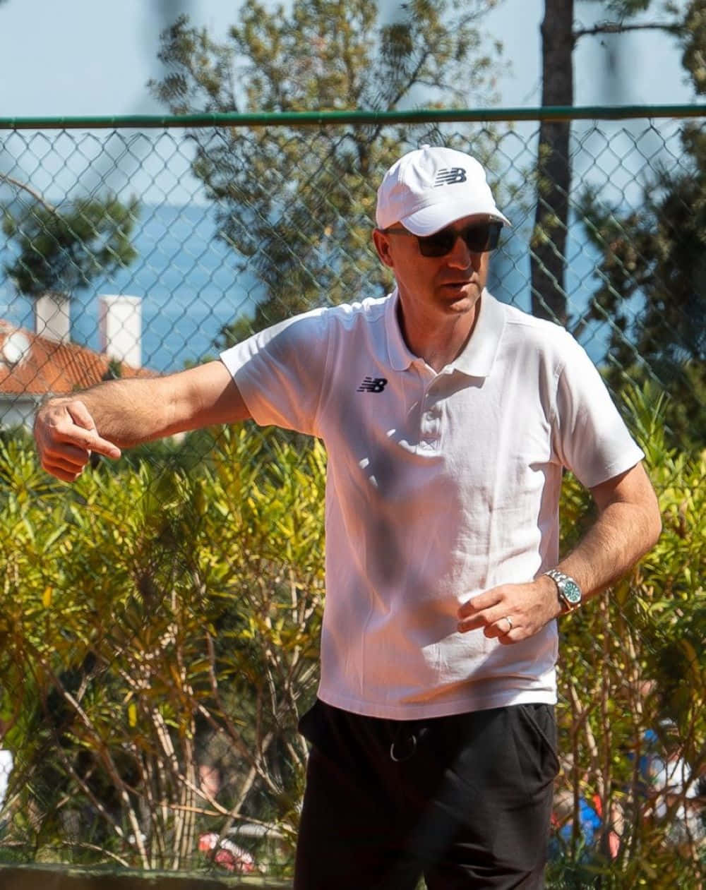 Tennis Coach Giving Instructions Outdoors Background