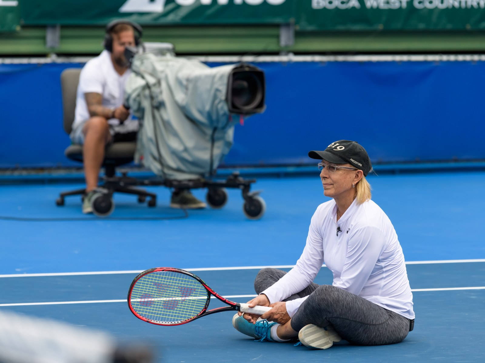 Tennis Icon Martina Navratilova Resting On Court Background