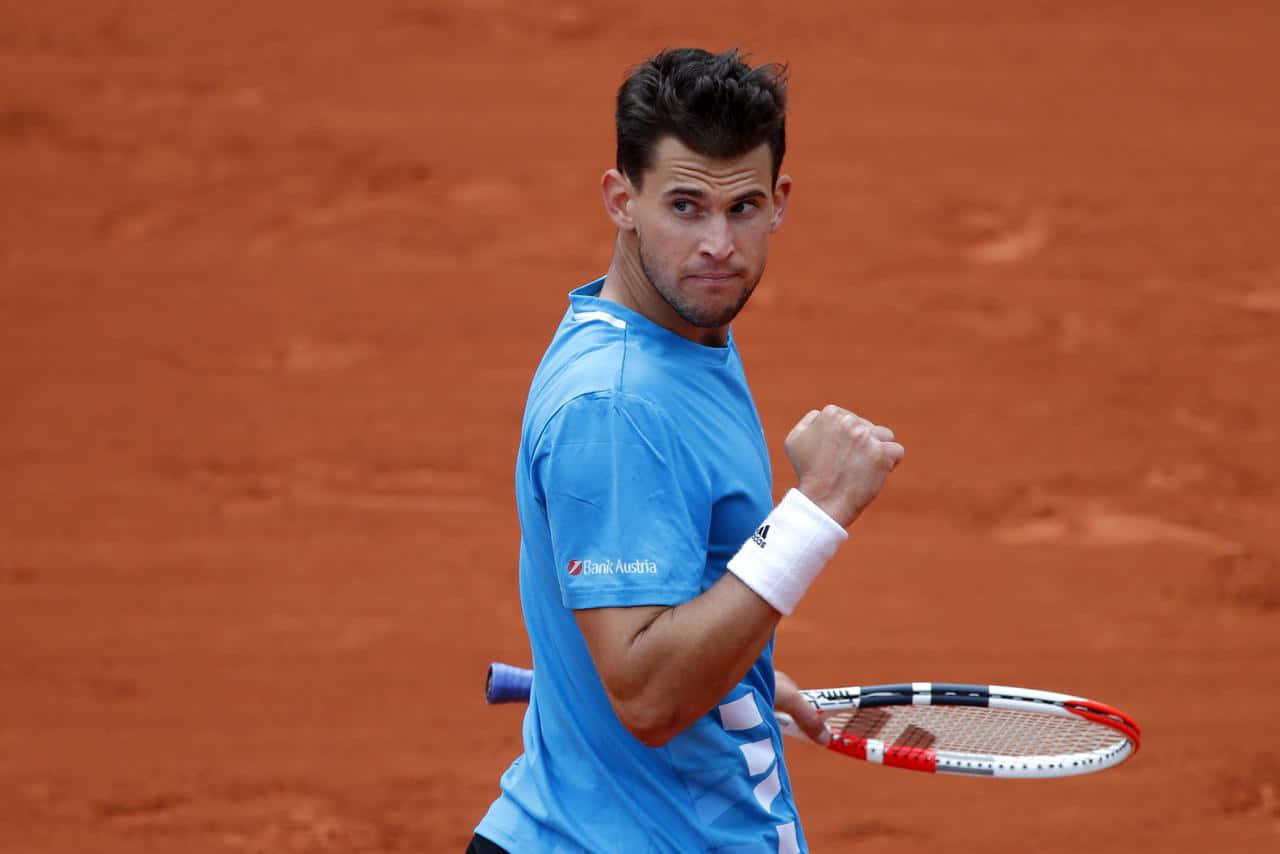 Tennis Player Celebratingon Clay Court Background