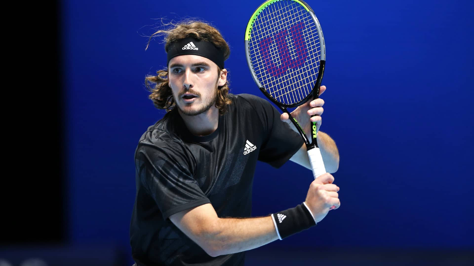 Tennis Star Stefanos Tsitsipas With Racket In Action Background