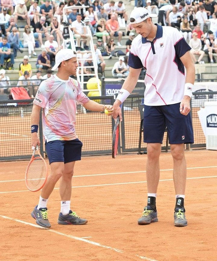 Tennis Superstars John Isner And Diego Schwartzman In An Intense Match Background